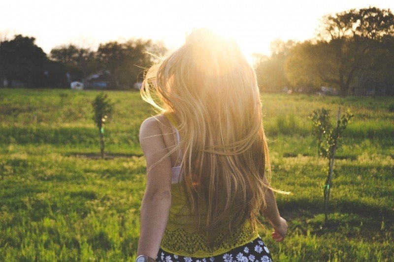 rear-view-of-blonde-woman-in-meadow-at-sunset.jpg